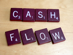 Picture of scrabble word tile that says Cash Flow which retail installment cotracts financing is a part of.